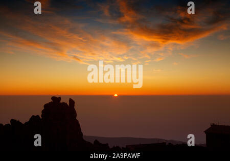 Sunrise on Teide, the tallest mountain of Spain and Atlantic Basin, view south east. rising sun, cablecar station to the right Stock Photo