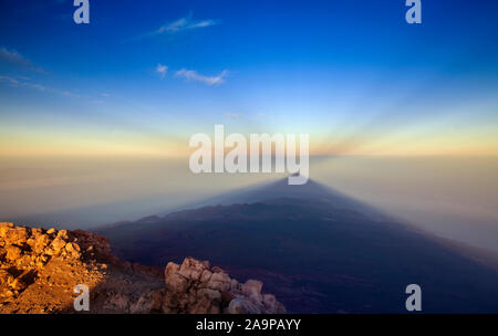 Sunrise on Teide, the tallest mountain of Spain and Atlantic Basin, view west towards  shadow of volcano cast onto the morning mist, lower levels of T
