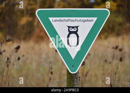 Nature preserve area in Lower Saxony, Germany. Green sign with black owl indicating a landscape reserve. Symbol for German landscape protection area. Stock Photo