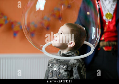 Children's holiday. The boy in the soap bubble. Child have fun at the party. Stock Photo