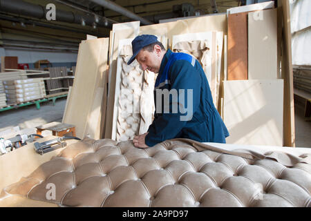 Belarus, the city of Gomil on April 29, 2019. Wood processing plant.Worker in the workshop for the production of beds. The master makes luxury furnitu Stock Photo