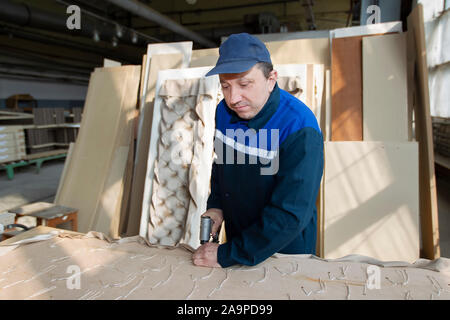 Belarus, the city of Gomil on April 29, 2019. Wood processing plant.Worker in the workshop for the production of beds. The master makes luxury furnitu Stock Photo