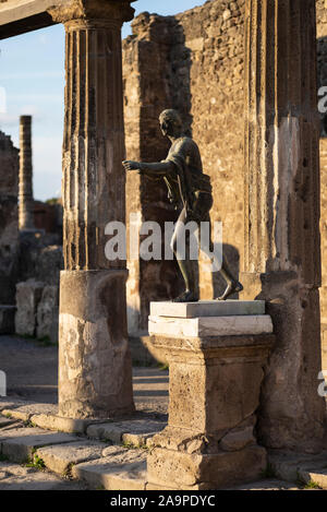 Pompei. Italy. Archaeological site of Pompeii. Tempio di Apollo / Temple of Apollo, bronze replica of the statue of Apollo Saettante (archer) shooting Stock Photo