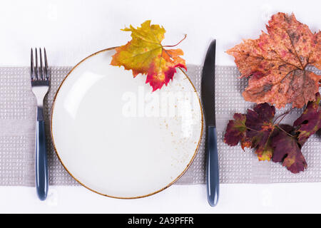 Cozy festive fall table setting with colorful autumn leaves. Minimal restaurant menu concept. Flat lay, top view Stock Photo