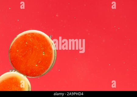 Oil drops in water. Abstract background, dominant red with yellow-gold accents. Place for text. Stock Photo
