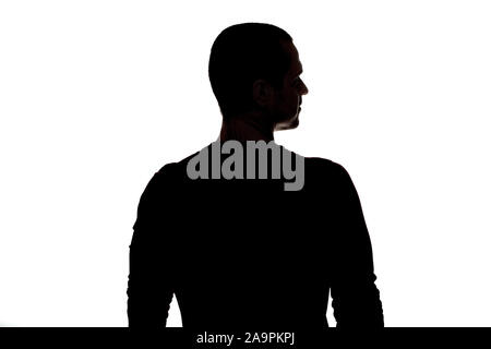 Silhouette of adult man standing back to camera in studio Stock Photo