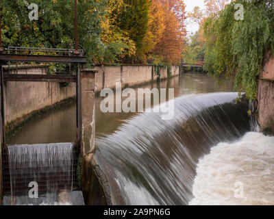 the water of the river gets speed after the jump of a small waterfall. autumn landscape on the outskirts of Milan Stock Photo