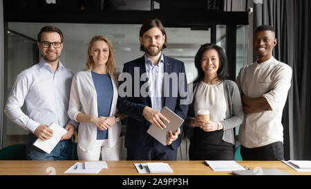 Portrait of confident team leader standing with colleagues. Stock Photo