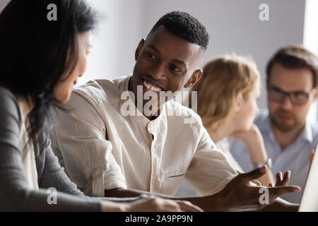Happy african american young worker discussing project ideas with leader. Stock Photo