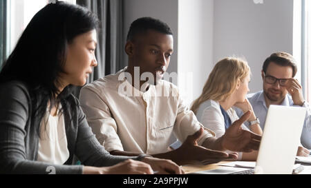Focused african american employee discussing working issues with korean supervisor. Stock Photo