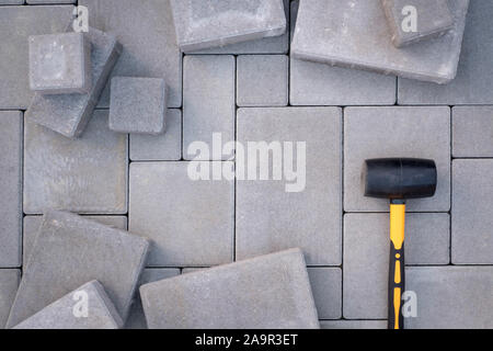 Paving stones paving background. Installing tools on foreground Stock Photo