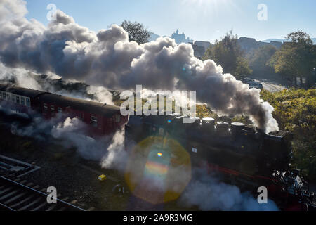 30 October 2019, Saxony-Anhalt, Wernigerode: A steam locomotive of the Harzer Schmalspurbahnen (HSB) leaves the station Wernigerode. The Wernigerode Castle rises in the background. HSB's operations changed from a summer to a winter timetable on 26 October. Photo: Klaus-Dietmar Gabbert/dpa-Zentralbild/ZB Stock Photo
