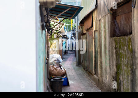 Narrow alley in the slums. Poor neighborhood. Marginal living standards. Garbage, old things and bicycles in the area where not rich people live Stock Photo