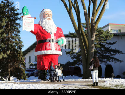 Frankenmuth, USA. 16th Nov, 2019. A mother takes photos of her children with a 5-meter-high Santa Claus statue outside the Bronner's Christmas Wonderland, a retail store that promotes itself as 'the world's largest Christmas store', in Frankenmuth of Michigan state, the United States, Nov. 16, 2019. Credit: Wang Ping/Xinhua/Alamy Live News Stock Photo