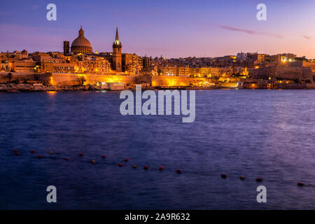 City skyline of Valletta in Malta at dusk, view from Marsamxett Harbour on Mediterranean Sea Stock Photo