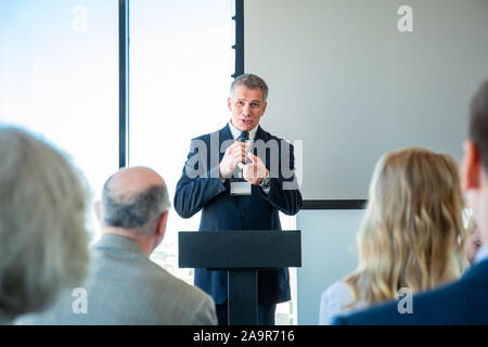 Audience listening to presentation of business speaker at conference Stock Photo