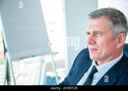 Portrait of mature business man sitting at conference in office with displeased, disappointed, tired facial expression Stock Photo