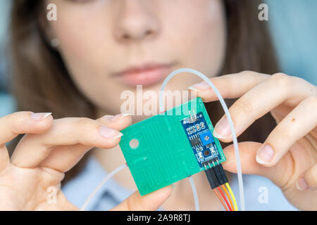 Young scientist woman in microbiological lab with lab-on-chip LOC microfluidic device Stock Photo