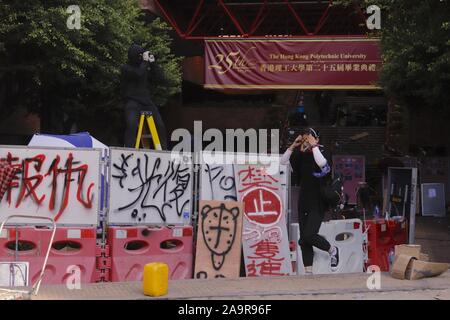 November 17, 2019, Hong Kong, CHINA: Sentinel look out for riot police, a female student put on protective gear and join the battle outside main entrance of Hong Kong Polytechnic University.Nov-17,2019 Hong Kong.ZUMA/Liau Chung-ren (Credit Image: © Liau Chung-ren/ZUMA Wire) Stock Photo