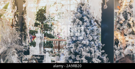 View of a shop full of beautiful adorns for Christmas and New Year eve holiday. Many decorations with christmas tree, baubles, lights, snowflakes and Stock Photo