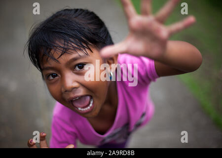 Bali / Indonesia - 03.16.2013: Parade on the street of Bali island. A little girl takes part in the ceremony, portrait close-up Stock Photo