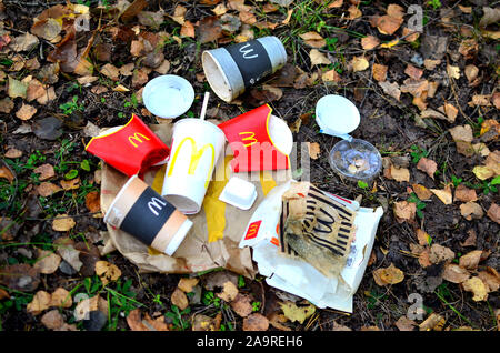 19.09.2019 Minsk, Belarus: Discarded paper coffee cups, cola and fast food packaging on the ground. People left behind trash. Mcdonalds rubbish backgr Stock Photo