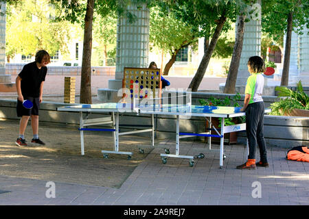 Two teenagers playing table tennis in the Carlos Corella Jacome Plaza near the Library in Tucson AZ Stock Photo