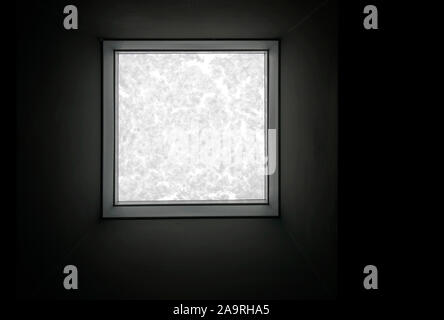 View through the roof window covered by melted snow from inside the building on the black background. Stock Photo