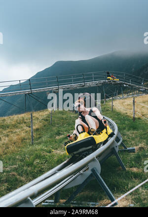 Ticino, Switzerland - August 5, 2019: Lady enjoy bobsleigh coaster on the hills of Monte Tamaro Stock Photo