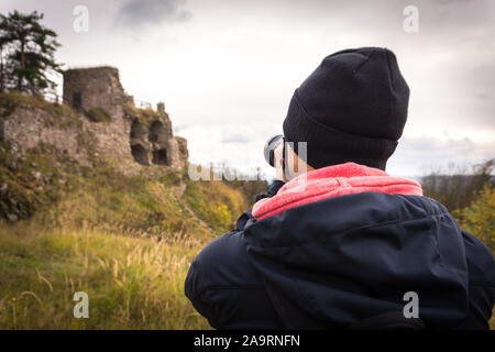 Young man tourist taking photos of castle ruin. Tourism. Stock Photo