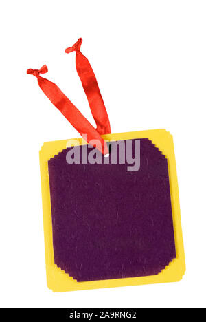 A purple and yellow colored blank gift tag with a red ribbon attached. The cardboard paper has scalloped edges. Isolated on white. Stock Photo