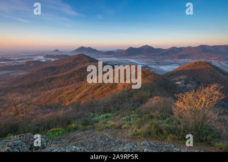 Sunrise views of the Euganean Hills just outside of Padua. Misty valley bottoms and bushy hills painted by dawn colours. Fog in the hills at sunrise. Stock Photo