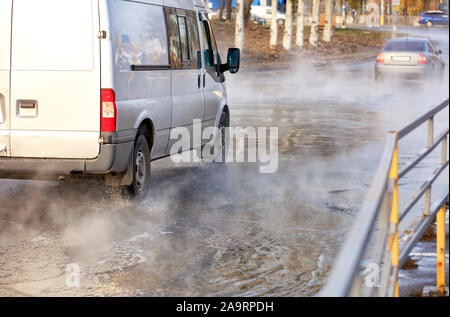 The road flooded with hot water after the breakthrough of the city heating main. Stock Photo