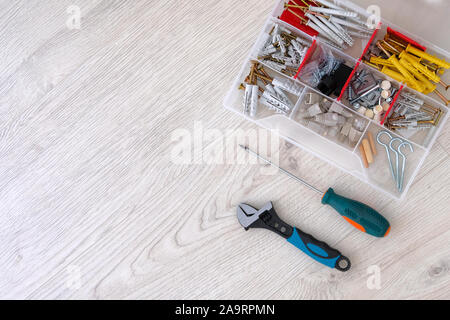 Flat lay of tools, parts and screwdrivers on white wooden background, close up. Repair in house with special tools. Copy space. Stock Photo