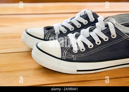 Pair of sneakers on the lacquered wooden floor, side view Stock Photo