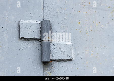 Metal hinge welded to the two steel plates, painted in light gray color, close-up Stock Photo