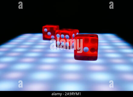 Red dice on a table with neon lights, conepia of board games Stock Photo