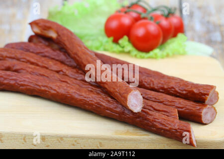 Traditional Polish smoked kabanos on wooden board, closeup Stock Photo