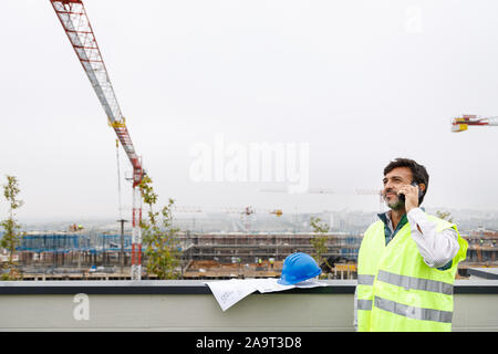 Engineer talking on the phone while working on the construction of luxury homes Stock Photo