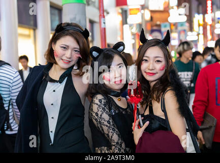 Tokyo, Japan - October 31st, 2018: Three young women wearing halloween costumes in a street in Tokyo, Japan Stock Photo