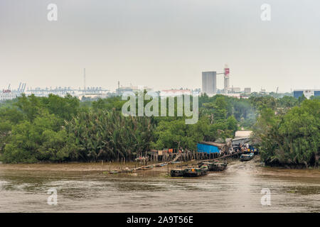 Ho Chi Minh City Vietnam - March 12, 2019: Song Sai Gon river inlet leading to slums, hidden in green vegetation. Rudimentary wooden piers for small b Stock Photo