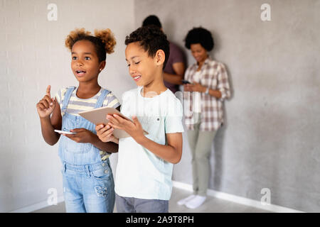 Happy african family using digital devices, tablet, smartphone. Technology concept Stock Photo
