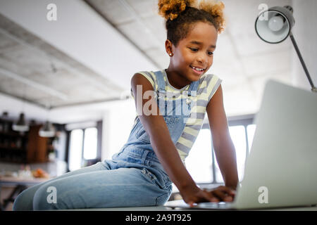 Game, study, fun concept. Happy children spending time with notebook and modern technology. Stock Photo