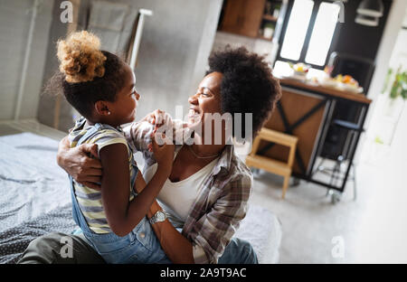Happy mother playing, having fun, hugging with her daughter at home Stock Photo