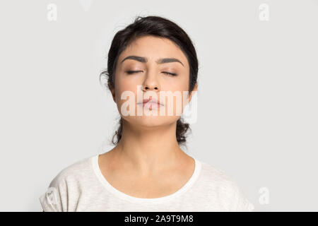 Calm Indian girl with closed eyes breathing deep, meditating Stock Photo