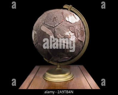 A very old soccer ball, is replacing the terrestrial globe.. Stock Photo