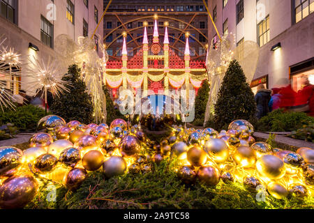 Christmas season decorations at Rockefeller Center Plaza with view of Saks Fifth Avenue holiday light display. Midtown Manhattan, New York City, NY Stock Photo
