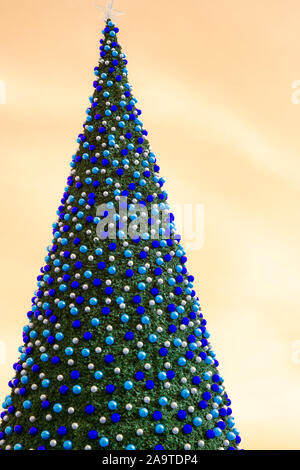 christmas tree with decorates balls and large beautiful star at the top with orange sky Stock Photo