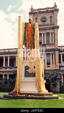 The statue of King Kamehameha I is draped with 30-foot-long plumeria flower leis for a state holiday, Kamehameha Day, celebrated annually on June 11th in the Pacific Ocean islands of Hawaii. Called Kamehameha the Great, he conquered the Hawaiian Islands and formally established the Kingdom of Hawaii in 1810, which later became the 50th state of the USA. The bronze statue with gold-leaf accents was unveiled in downtown Honolulu on the island of Oahu in 1883 and is the work of American sculptor Thomas Ridgeway Gould. The statue stands in front of the Judiciary Building. Stock Photo