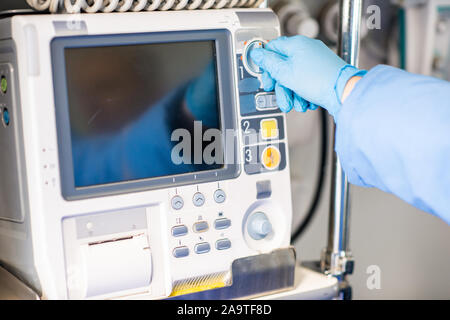 Paramedic in gloves adjusting medical first aid equipment inside ambulance car Stock Photo